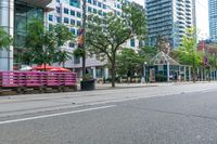 empty city street with lots of crates and people in the background, including some with umbrellas