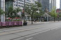 empty city street with lots of crates and people in the background, including some with umbrellas