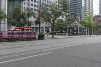 empty city street with lots of crates and people in the background, including some with umbrellas