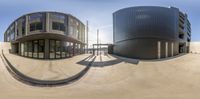 two circular buildings in an alley with blue skies in the background and a curved ramp below