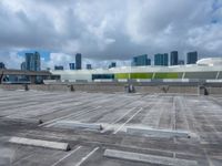 the view from a flat roof looking towards a city in the distance, with the sky and buildings across the road