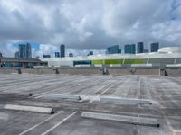 the view from a flat roof looking towards a city in the distance, with the sky and buildings across the road