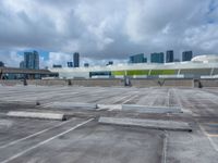 the view from a flat roof looking towards a city in the distance, with the sky and buildings across the road