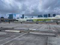 the view from a flat roof looking towards a city in the distance, with the sky and buildings across the road