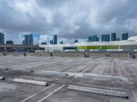 the view from a flat roof looking towards a city in the distance, with the sky and buildings across the road