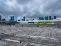 the view from a flat roof looking towards a city in the distance, with the sky and buildings across the road