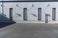 there is a white building with three large windows next to it and an alley way