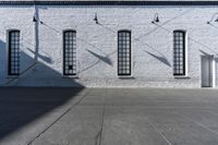 there is a white building with three large windows next to it and an alley way