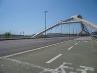 a truck driving across a bridge near a street corner near buildings and a bridge with many cables