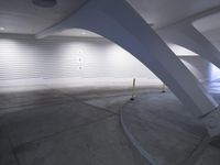 a black and white photo of an indoor swimming pool, and it has curved walls