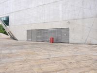 a red object sits on a wood floor near a white wall and large sliding garage