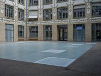 a large courtyard with some windows near an empty building is pictured on the opposite side