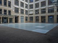 a large courtyard with some windows near an empty building is pictured on the opposite side