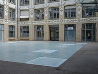 a large courtyard with some windows near an empty building is pictured on the opposite side