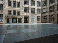 a large courtyard with some windows near an empty building is pictured on the opposite side