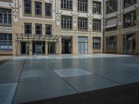 a large courtyard with some windows near an empty building is pictured on the opposite side