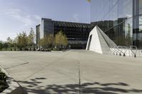 an urban courtyard with various benches and trees near a building under a clear sky with some buildings in the background