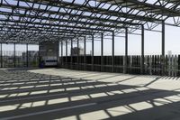 this is a picture of a covered area with concrete floors and a large roof and some windows