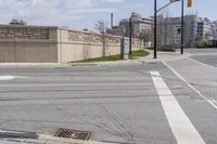 a large concrete wall at an intersection of two streets and a crosswalk with a traffic light above