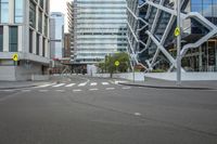 a crosswalk on a city street next to tall buildings, with an pedestrian sign