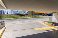 a view from under the overpass, looking towards an outside building with parking garages on both sides