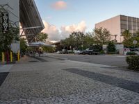 a crosswalk and walkway in an urban setting with the light in the sky shining behind it