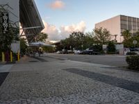 a crosswalk and walkway in an urban setting with the light in the sky shining behind it