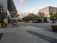 a crosswalk and walkway in an urban setting with the light in the sky shining behind it