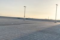 a man holding an umbrella over a parking lot with lots of empty spaces on each side