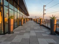 the sun is setting on the roof terrace overlooking the city as the sun sets behind the buildings