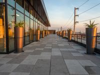 the sun is setting on the roof terrace overlooking the city as the sun sets behind the buildings