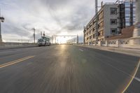 the road is wide and empty for the cars to travel on the streets in front of a building under construction