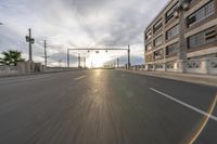 the road is wide and empty for the cars to travel on the streets in front of a building under construction