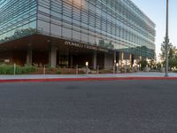 two grey blocks sitting next to a tall building on a sidewalk in front of grass