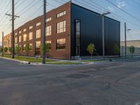 an empty street in front of a large red brick building on the other side of the road is a street light that has a line for motorists