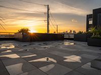 sun setting on a rooftop with square tiles as a focal point to the area's buildings