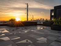 sun setting on a rooftop with square tiles as a focal point to the area's buildings