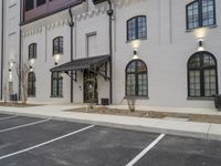 a white building has a tall brick building on the other side of the street with lots of windows and lights