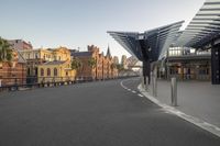 an empty street lined with tall buildings and a covered walkway on the side of it