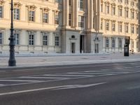 a person is walking by some buildings and a street light on a sidewalk in front of them