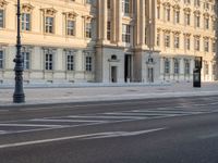 a person is walking by some buildings and a street light on a sidewalk in front of them