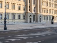 a person is walking by some buildings and a street light on a sidewalk in front of them