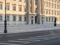 a person is walking by some buildings and a street light on a sidewalk in front of them