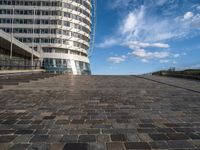 a walkway up to the top of a building on the beach with people and buildings in the background