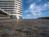 a walkway up to the top of a building on the beach with people and buildings in the background