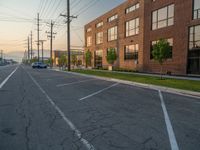 an empty street in front of a large red brick building on the other side of the road is a street light that has a line for motorists