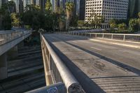 a metal pole with graffiti is on the street overpass of a bridge surrounded by buildings