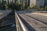 a metal pole with graffiti is on the street overpass of a bridge surrounded by buildings