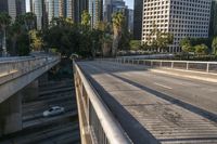 a metal pole with graffiti is on the street overpass of a bridge surrounded by buildings