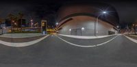 an image of a skate boarder on a ramp near some buildings at night time